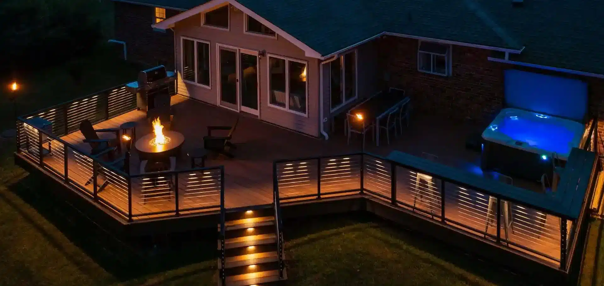 Modern deck with built-in lighting, cable railing, and a fire pit