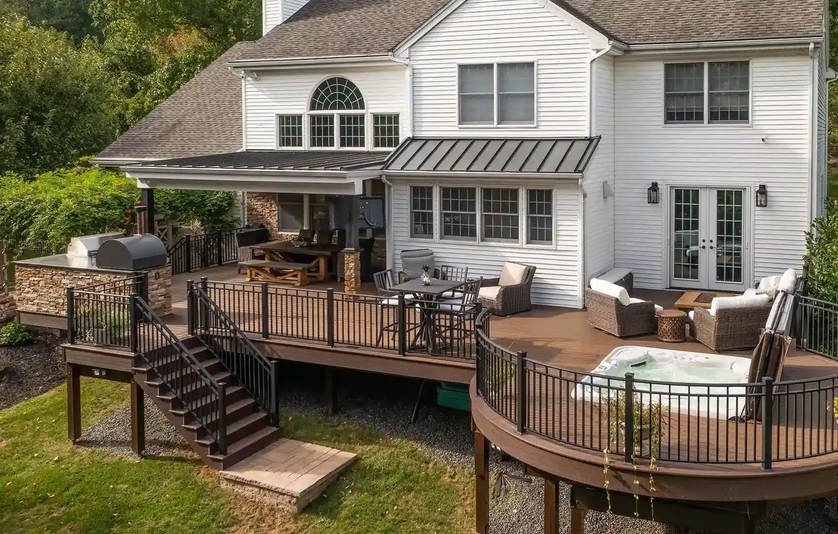 Curved composite deck with black metal railing and outdoor dining set