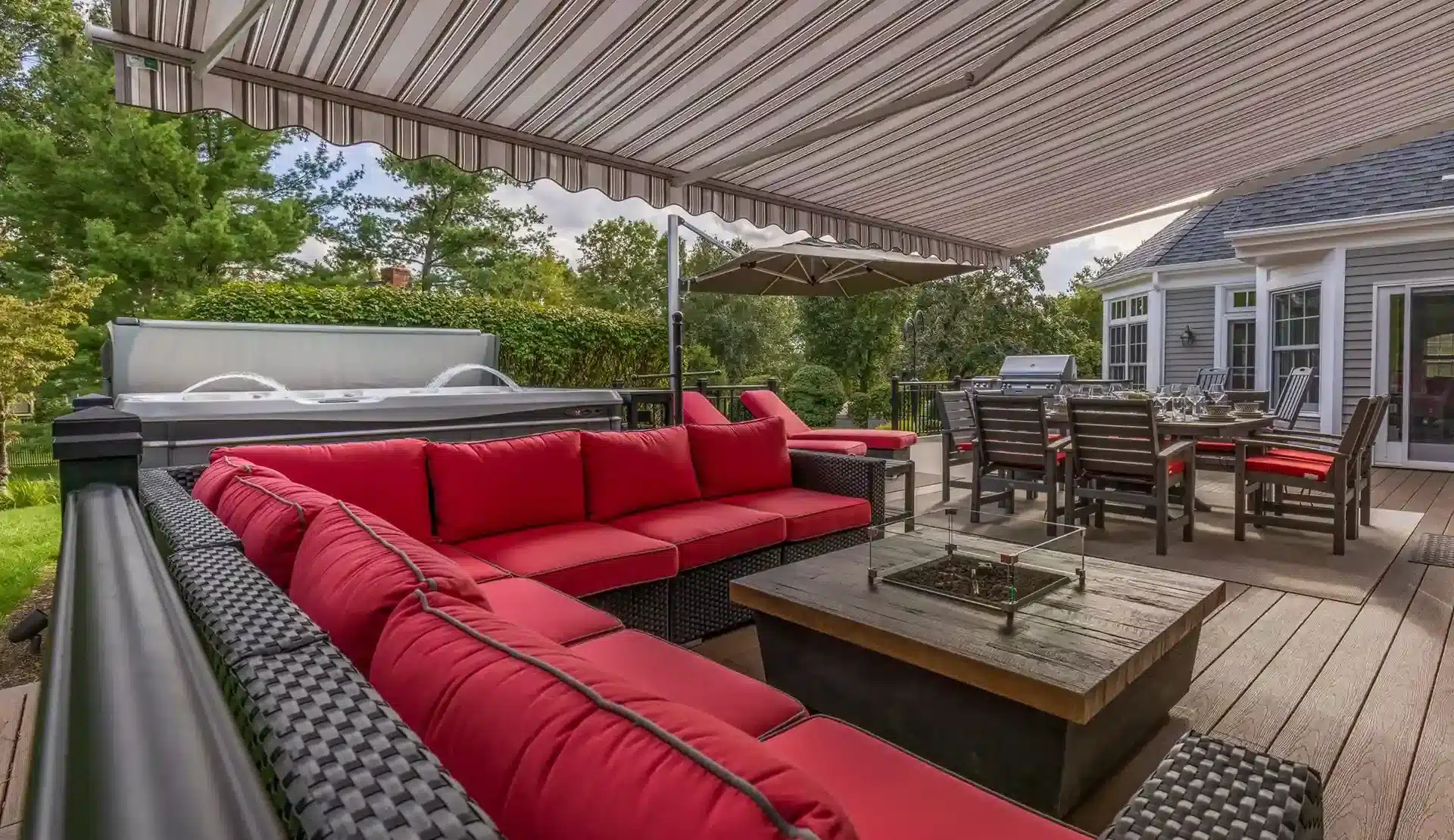 custom deck with an awning cover, outdoor furniture, and a fire table
