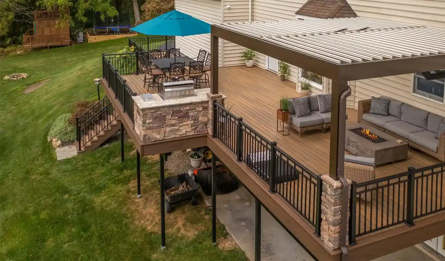  louvered roof pergola on a custom deck with outdoor kitchen, fire feature, and outdoor living room and dining room