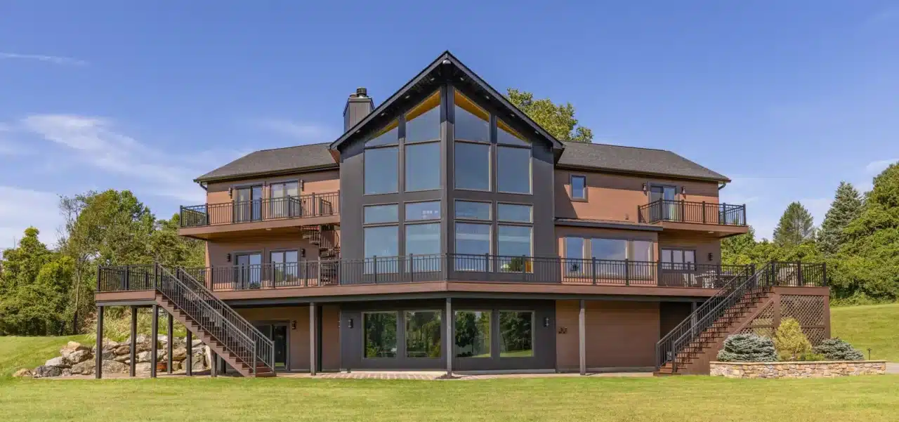 Photo of large multi-level Trex Transend deck in Hampton, NJ, with aluminum railings, dual staircases, and a spiral staircase on a modern home facade.