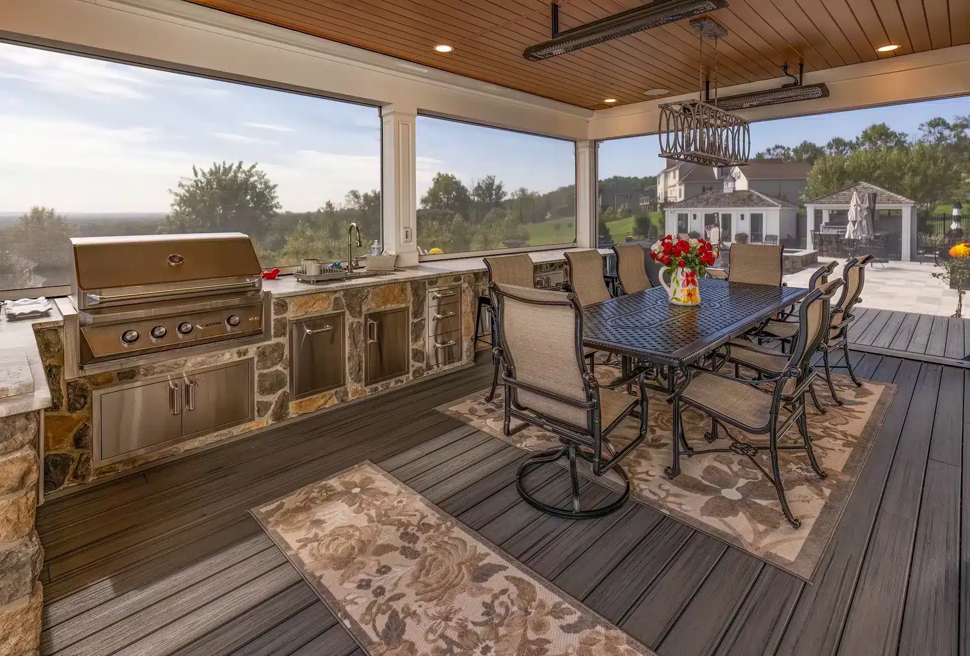 Photo of an outdoor kitchen on a deck with Phantom Screens to provide protection against bugs, insects, sun, and wind