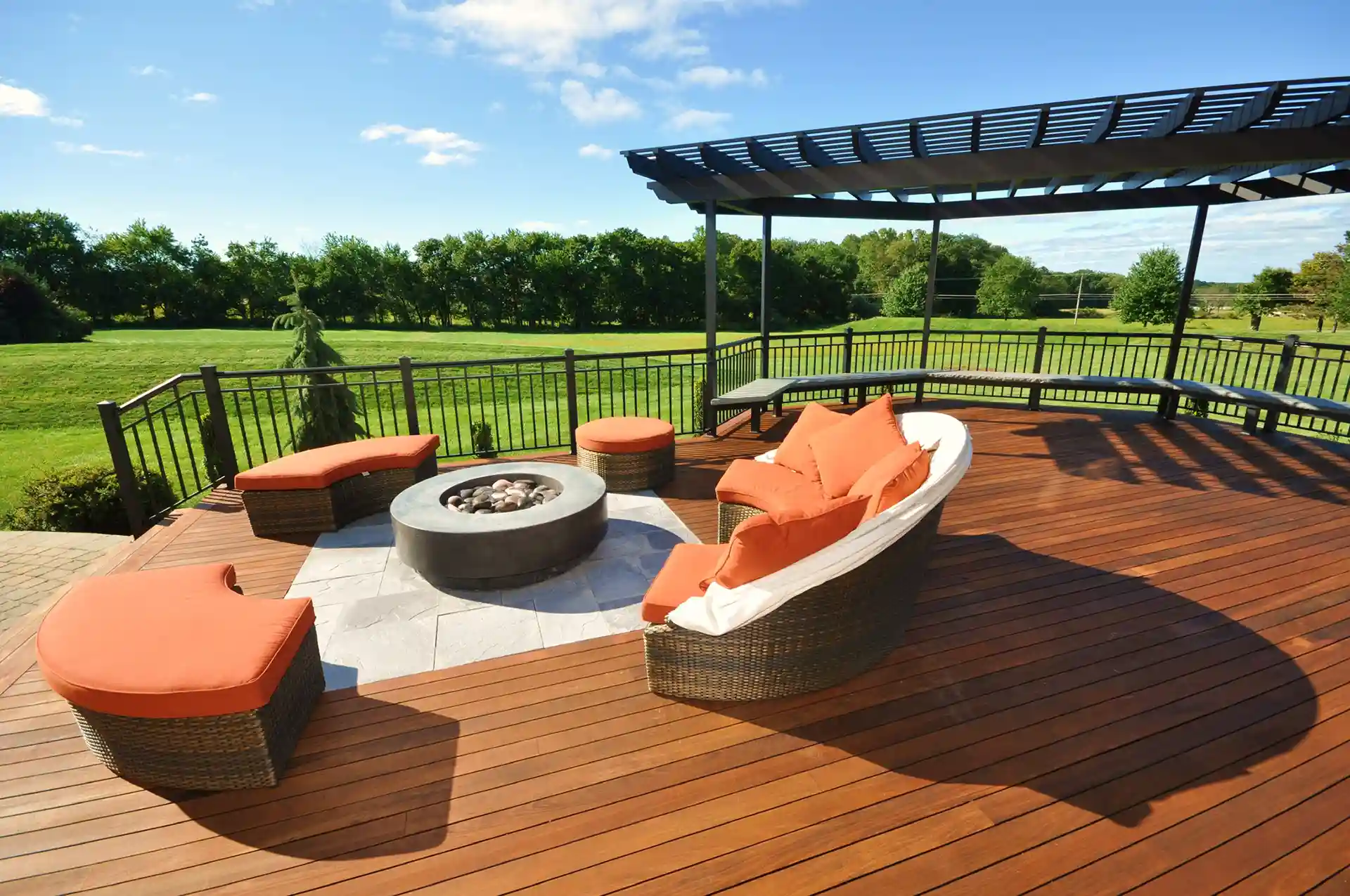 PHoto of a wood deck with modern pergola, outdoor furniture, and fire pit 
