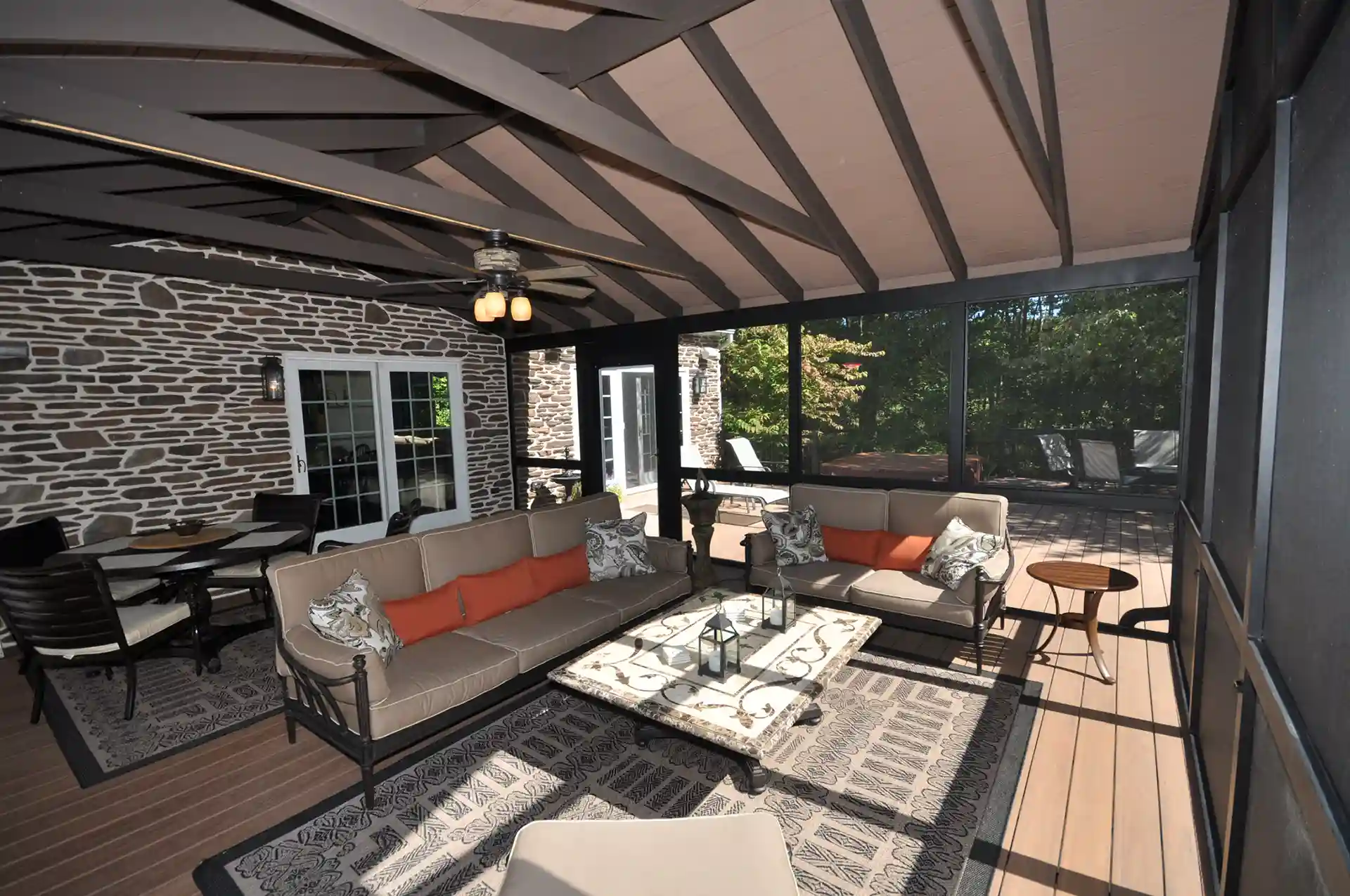 Photo of a covered, screened in porch/outdoor room.
