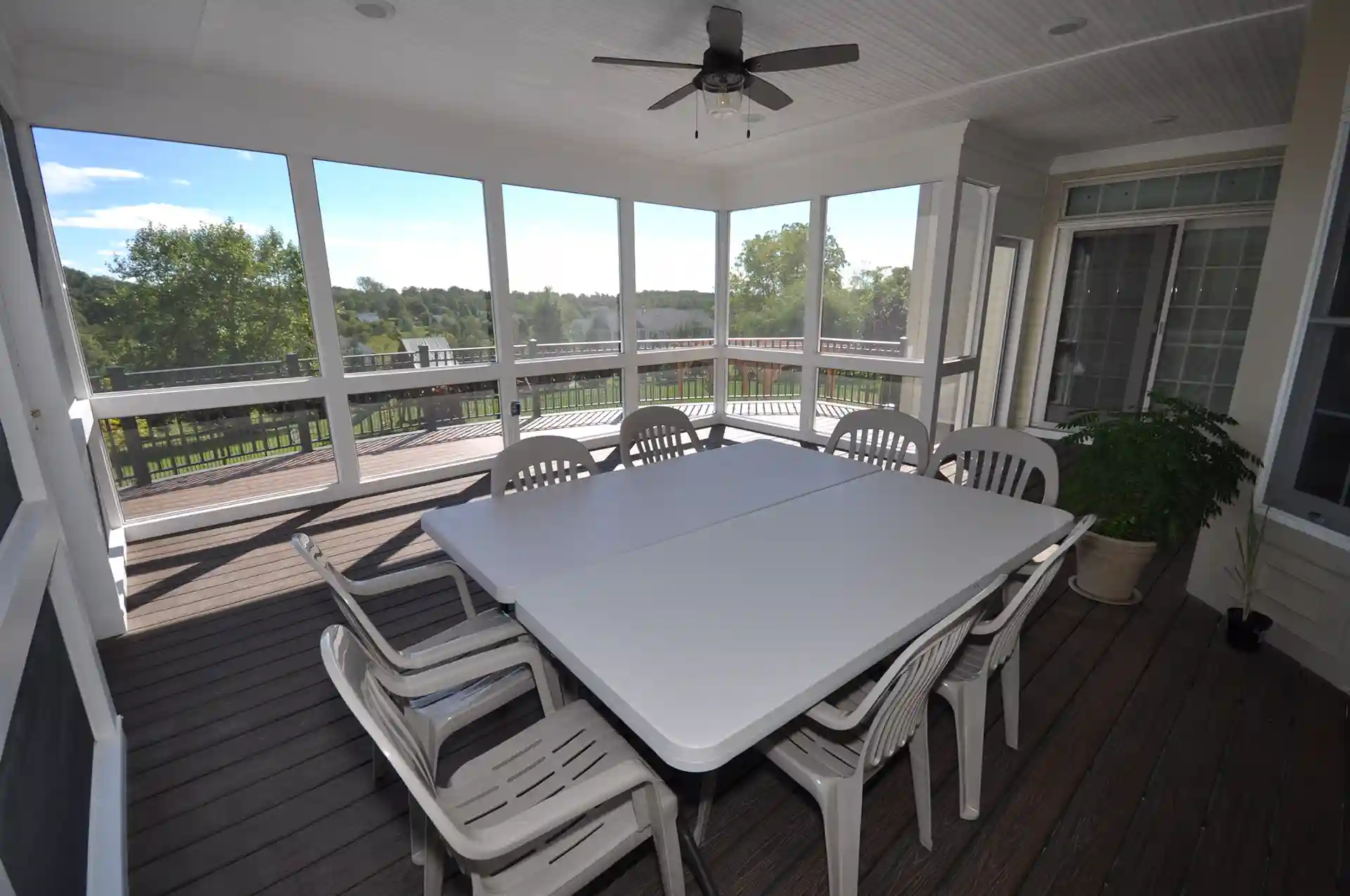 Photo of a screened porch with table and chairs.
