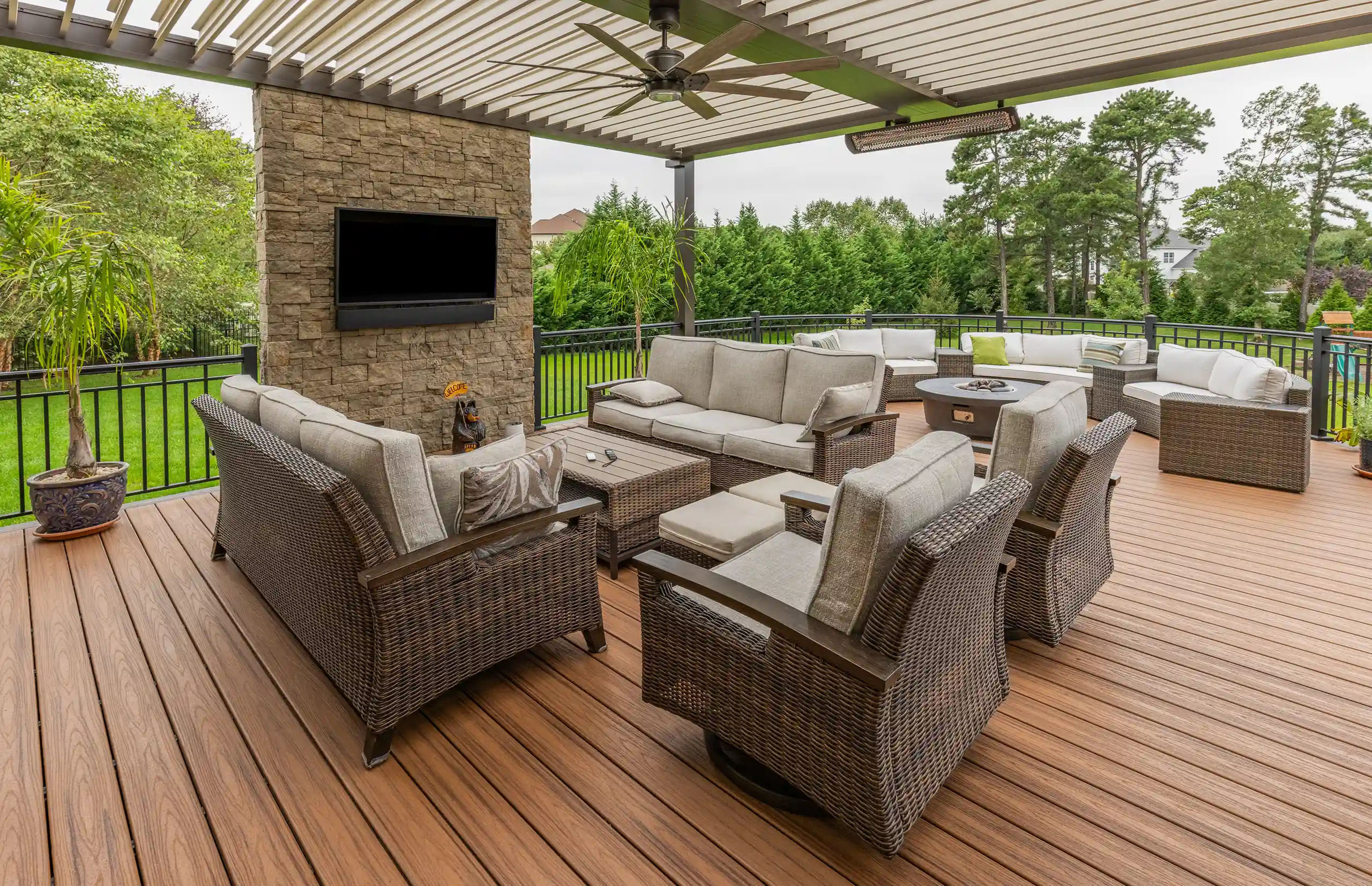 Photo of a deck with a louvered roof pergola, outdoor furniture, and entertainment area.