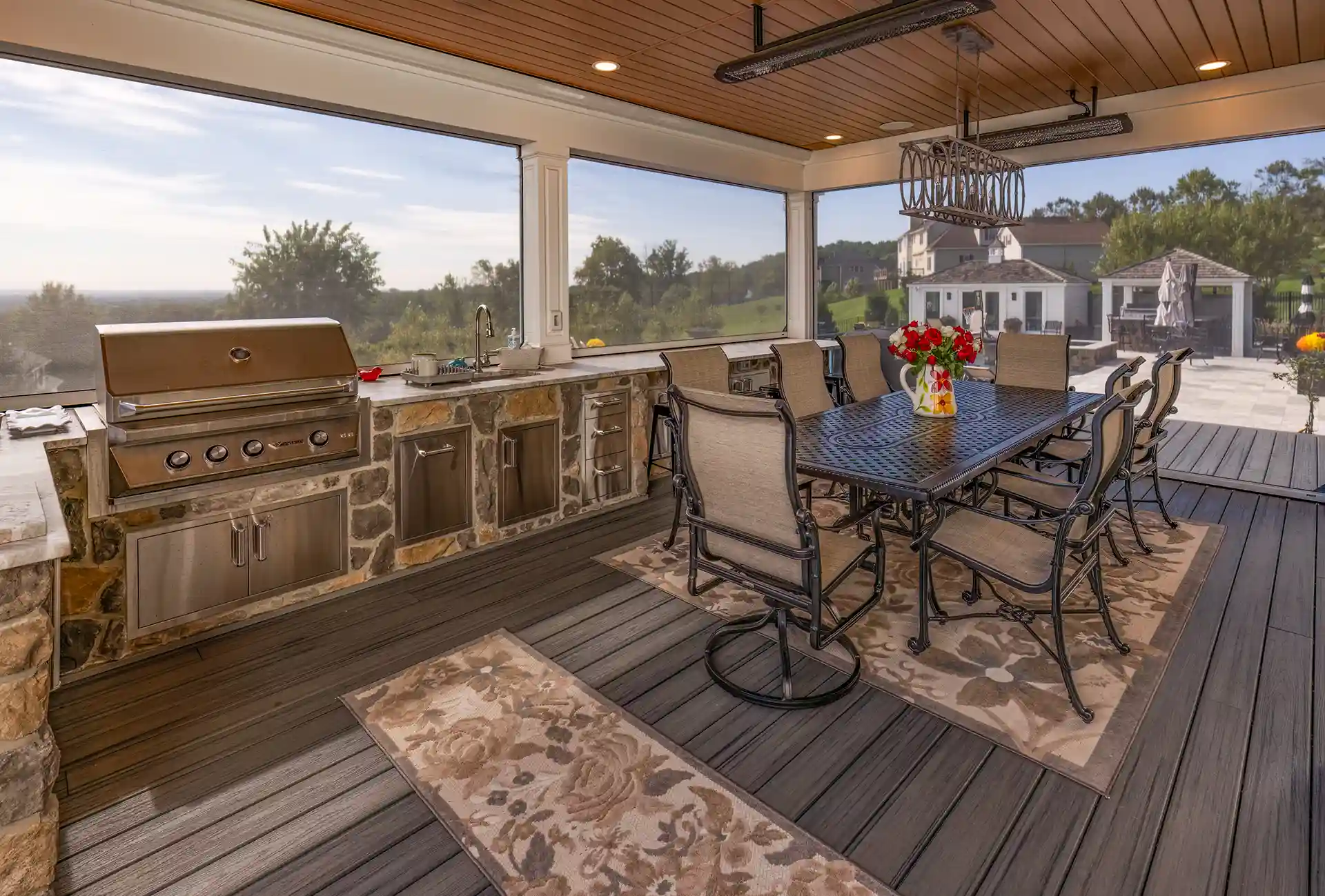 Photo of an outdoor kitchen under a deck with a finished ceiling.