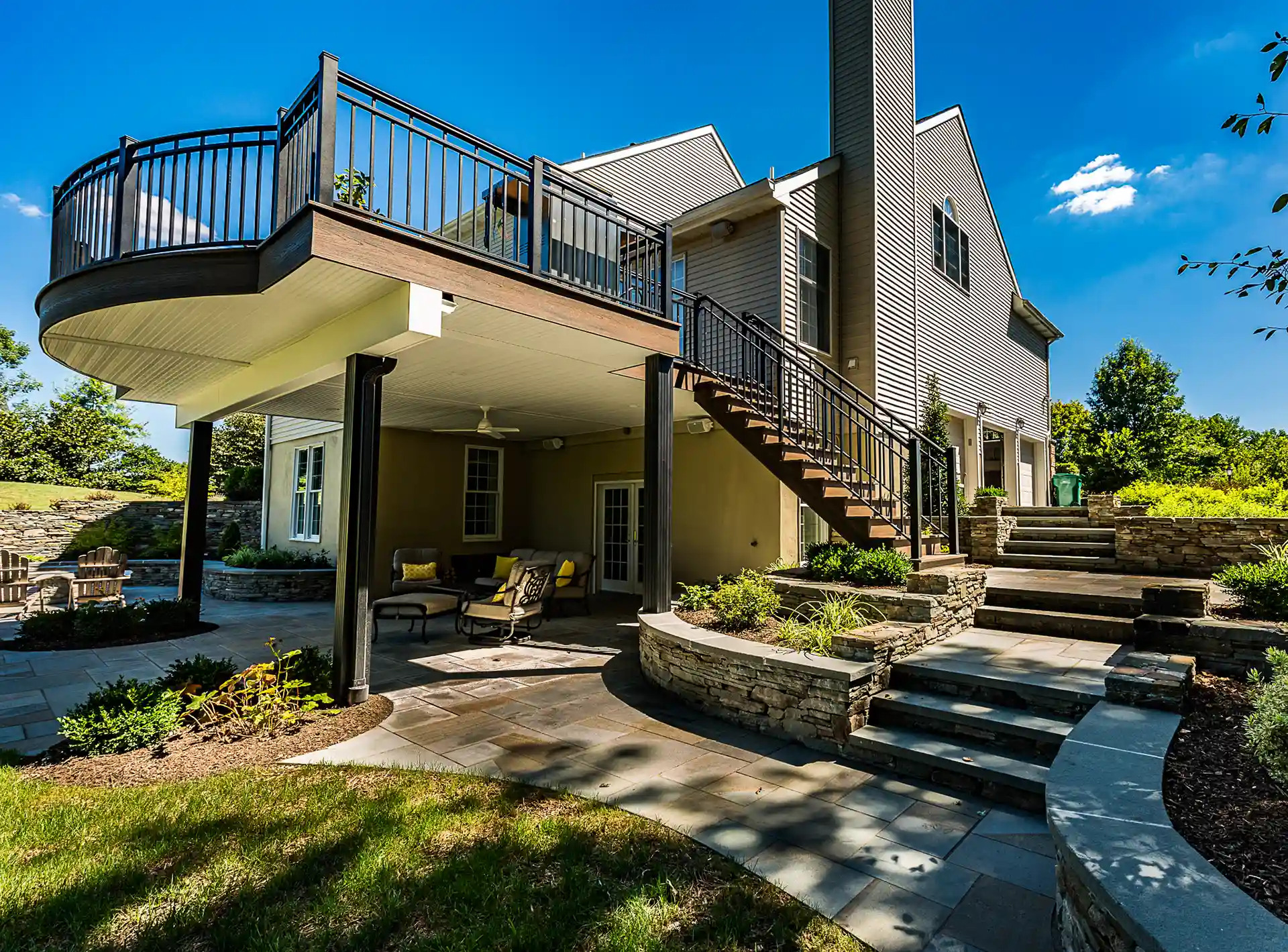 outdoor planter designs Photo of Tiered stone retaining walls with planting beds flank the stairs and patio area leading to the house.