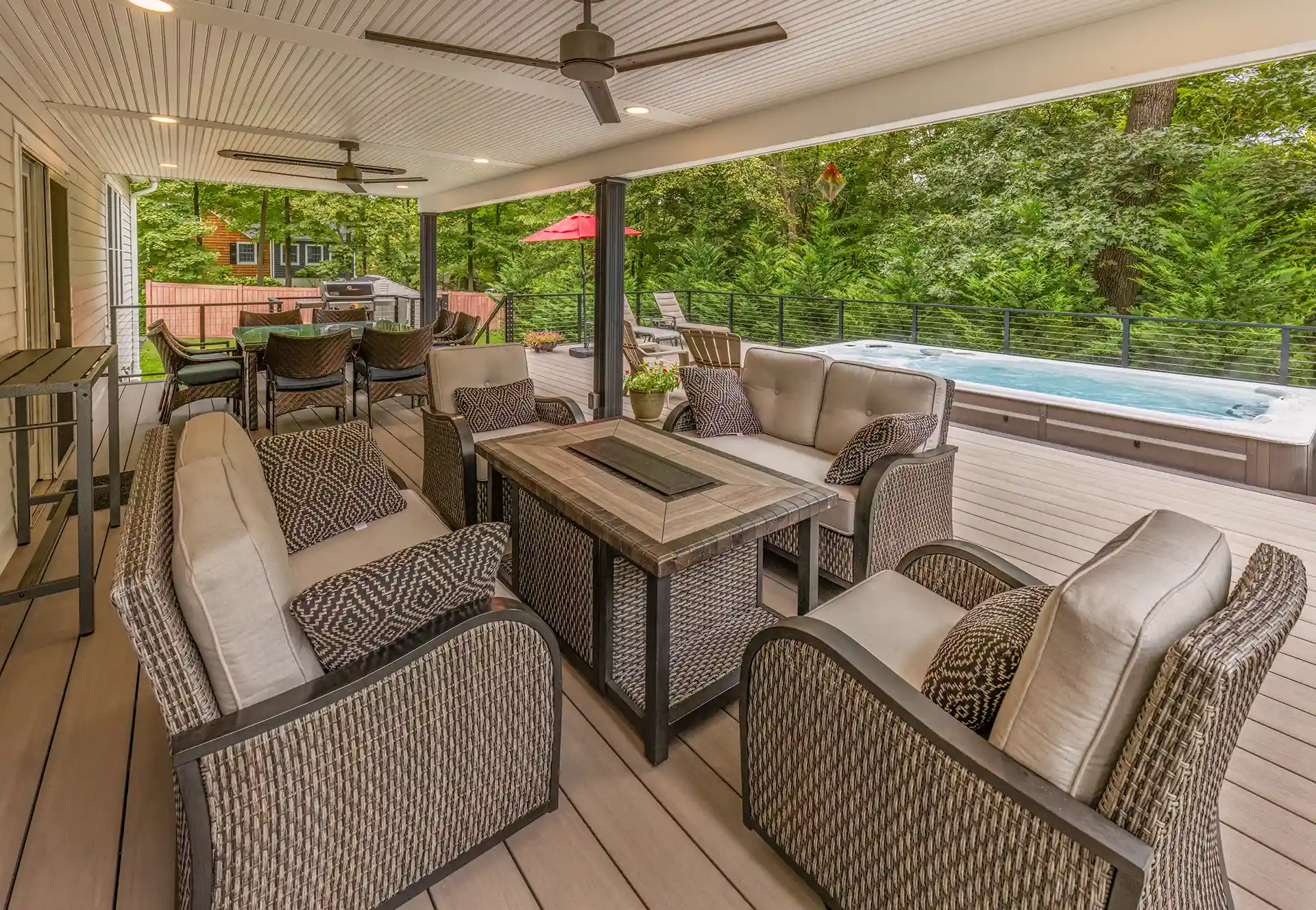 composite deck comparison Photo of an AZEK deck with outdoor furniture, ceiling fan, hot tub, and cable railing.